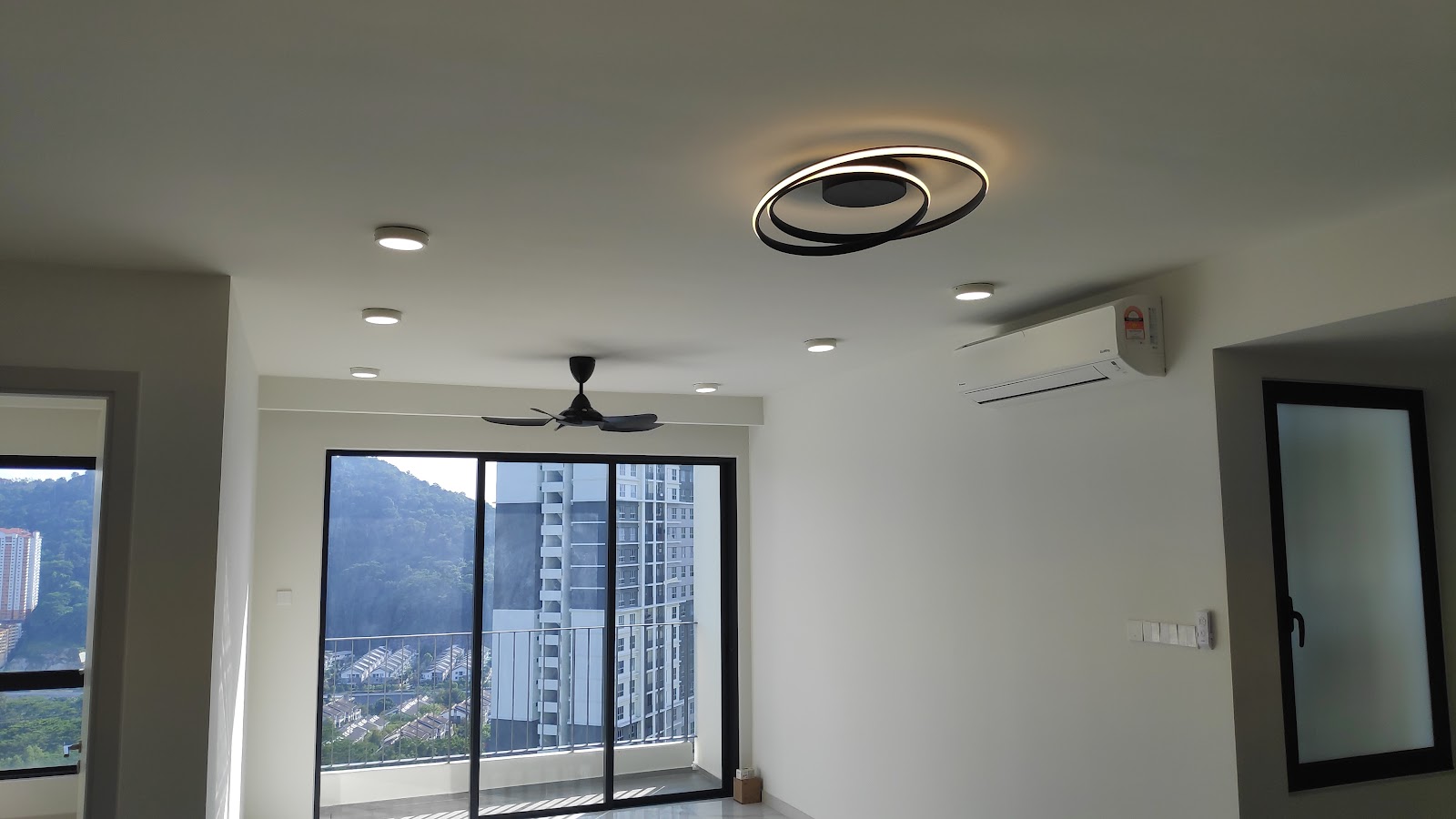 Finished living room with designer ceiling light, downlights and fan
